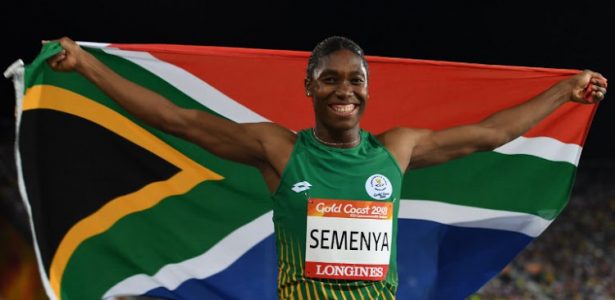 South Africa's Caster Semenya celebrates with flag after winning the athletics women's 800m final during the 2018 Gold Coast Commonwealth Games at the Carrara Stadium on the Gold Coast on April 13, 2018. / AFP PHOTO / SAEED KHAN